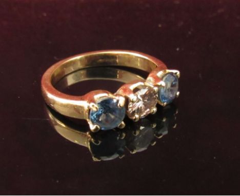 A gold sapphire and diamond ring the central diamond .50ct approx flanked by sapphires, unmarked. Size K, 3.2g