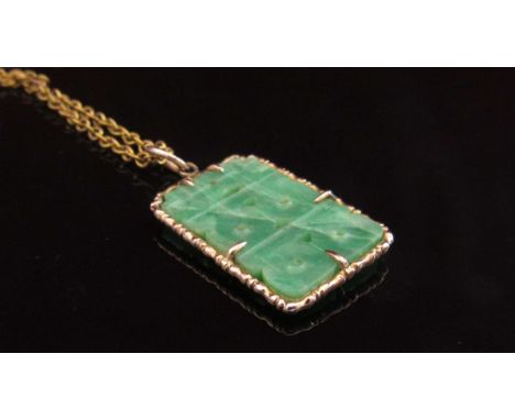 A gold and carved jade pendant marked 14k hung on a metal chain, 2.5cm x 1.8cm pendant, 3.2g pendant