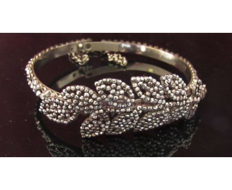A Georgian steel cut bead bangle with leaf detail and safety chain