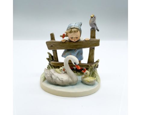 Hand-painted figurine depicting a young girl watching a swan swimming with ducklings while a bird sings on the fence post. Go
