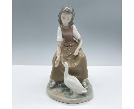 Glossy porcelain. Features a young girl dressed in a brown dress accompanied by a duck. Includes the original box. Nao by Lla
