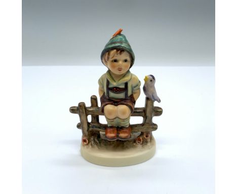 Hand-painted figurine depicting a boy sitting on a fence with a bird. Goebel backstamp on the bottom. This item has its origi