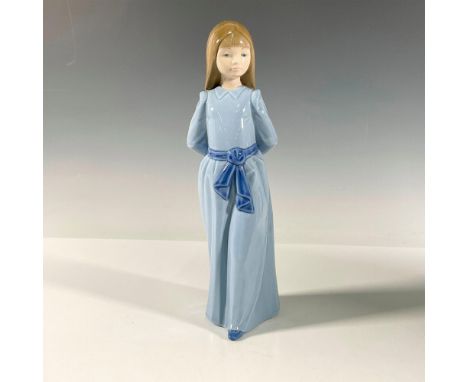 A young girl with her arms behind her wearing a blue dress, belt and shoes. Glossy finish. Lladro backstamp. This item has it
