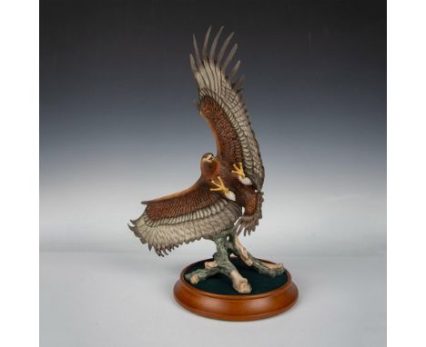 Majestic hand painted fine porcelain figure of an eagle swooping over a fallen branch with talons outstretched. Franklin Mint