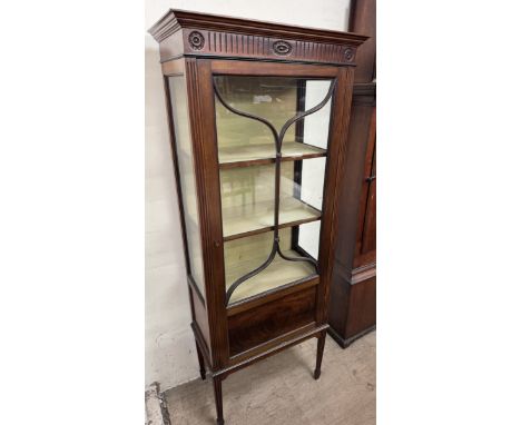 An Edwardian mahogany display cabinet with a moulded cornice above a glazed door and sides on square tapering legs and spade 