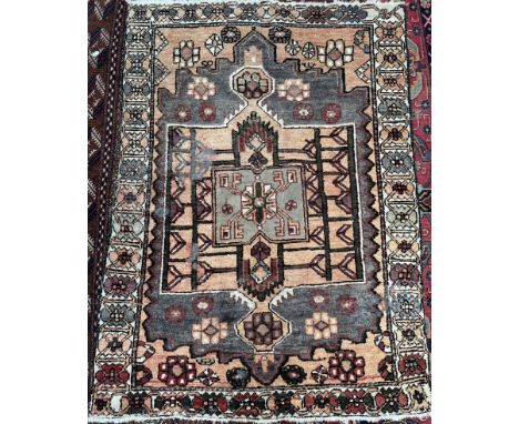 A rug with an orange ground and central medallion, the border decorated with stylised flowers, 190 x 143cm