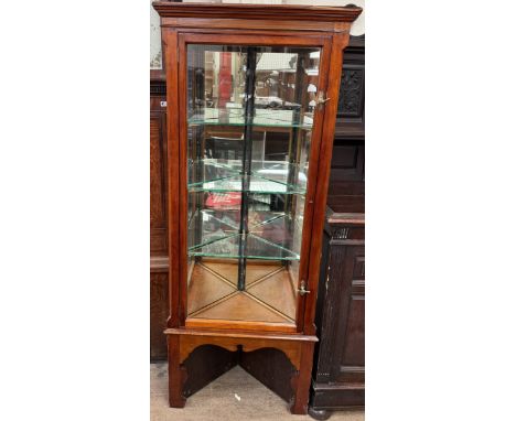 An Edwardian shop corner display cabinet with a moulded cornice above a glazed door and mirrored back on shaped legs