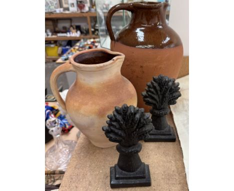 A pair of cast iron wheatsheaf doorstops together with a large terracotta ewer and a smaller terracotta pot/jug