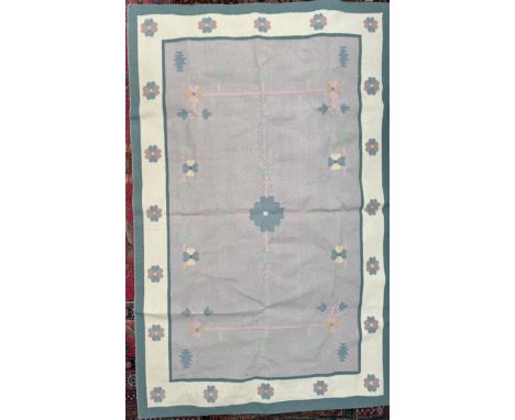 A large rug with a light purple ground and flower heads to a cream and green border, 285 x 182cm