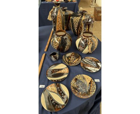 A collection of Studio Trizia South Africa pottery vases, plates and a jug decorated in leopard print, and bands of colour