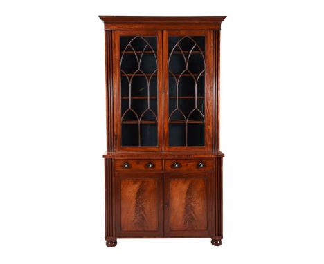 An early Victorian mahogany cabinet bookcase, circa 1850, the lancet moulded doors enclosing shelves, the cabinet base with t