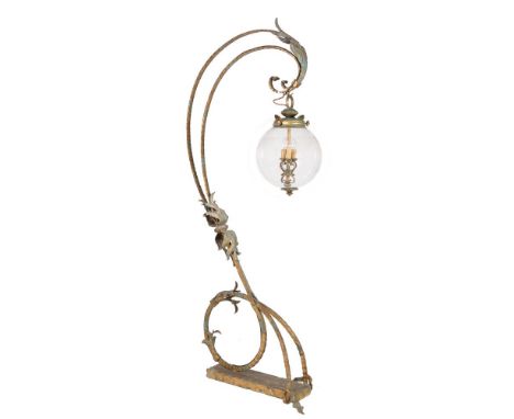 A patinated and gilt wrought metal standard lamp, the scrollwork frame supporting a lantern, 233cm high, 80cm long, 38cm wide