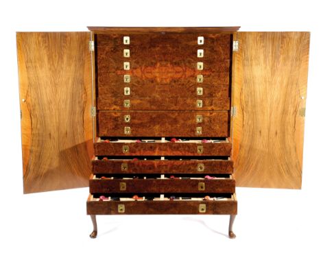 ALFRED DUNHILL. A RARE COLLECTION OF PIPES C.1974-76 the Queen Anne style walnut cabinet with a moulded cornice above a pair 