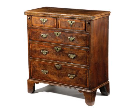 A GEORGE I WALNUT BACHELOR'S CHEST C.1720 with feather and crossbanding, the quarter veneered hinged fold-over top with a cad