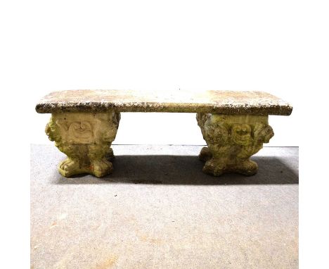 Concrete garden bench, the pedestals with lion mask corners, supporting a rectangular seat, length 122cm, depth 35cm.