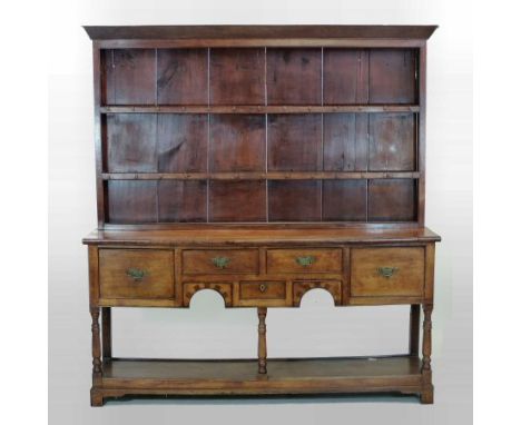 An 18th century style oak dresser, the plate rack above a frieze containing an arrangement of five short drawers and a pot sh