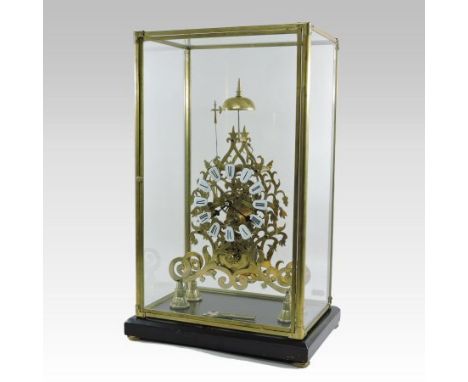 A brass skeleton clock, having enamel hours, surmounted by a bell, contained in a glazed case, on an ebonised plinth, 53cm ta