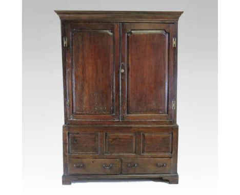 An 18th century oak press cupboard, enclosed by a pair of fielded panelled doors, containing dummy drawers and a pair of shor