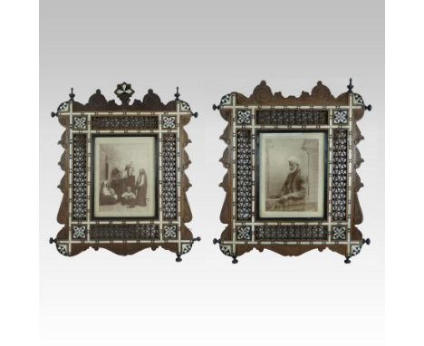 A pair of late 19th century Moroccan turned wooden photograph frames, inlaid with bone and mother of pearl and inset with por