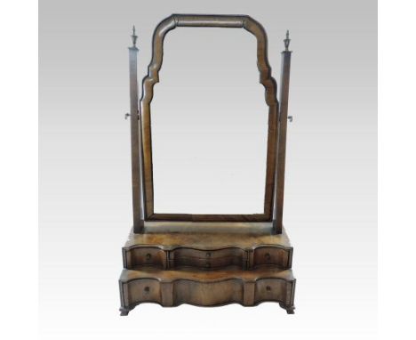 A Queen Anne style walnut serpentine swing frame toiletry mirror, the rectangular adjustable plate, over an arrangement of fo