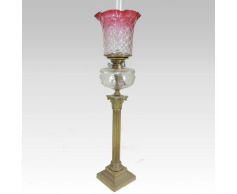 A large 19th century brass oil lamp, in the form of a Corinthian column, with a cut glass reservoir and frilled glass shade, 