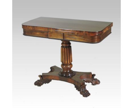 A late Regency rosewood D shaped folding card table, the hinged top, on a fluted column and platform base, terminating in paw