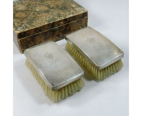 A pair of early 20th century silver backed clothes brushes, inscribed Boy Scouts and monogram J. E. H., together with a comb,