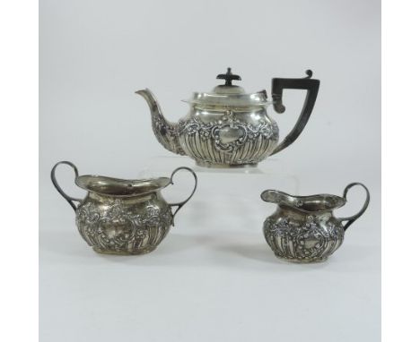 An early 20th century three piece silver tea service, of oval shape, with repousse decoration, Birmingham 1915 (3)