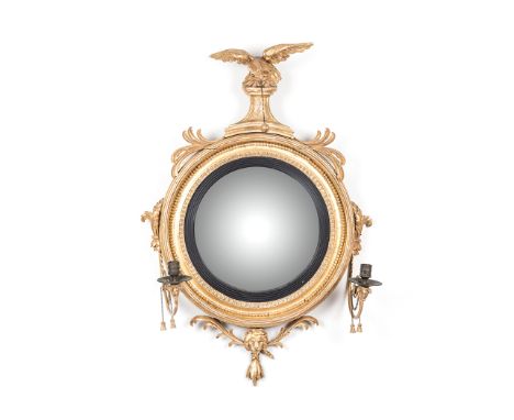 A REGENCY GILTWOOD TWO-LIGHT CONVEX GIRANDOLE MIRROR, CIRCA 1810 the circular frame with a beaded and an acanthus-leaf border