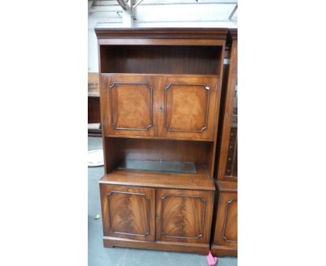 A 20th century mahogany cupboard unit, shelf over two cupboards above two cupboards with bracket feet