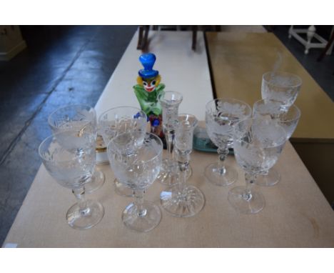 A set of eight etched glass wine glasses with a pair of crystal candlestick holders and a Venetian glass clown