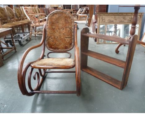 An early 20th century bent wood Thonet type rocking chair with a hanging shelf