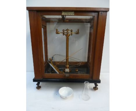 A set of laboratory scales in a glazed wooden case with various makers and repairers labels including Loertling of London, Pa