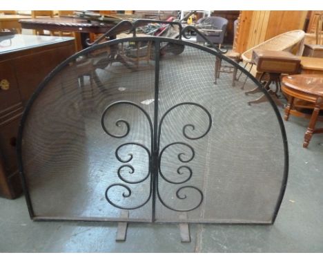 A cast iron demi lune fireguard with scrolling design, 86cmH