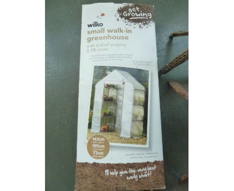 A Wilko small walk in greenhouse with six shelf staging and cover