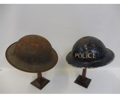 A Police metal helmet and one other. 