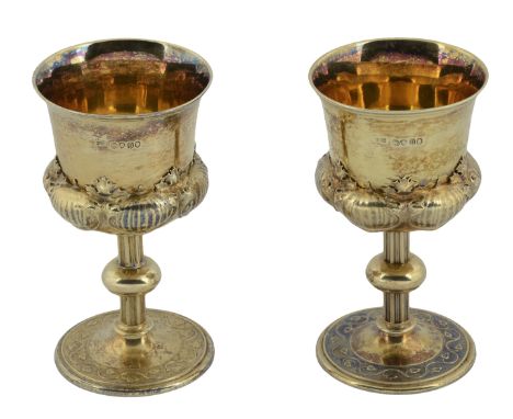 A pair of William IV silver gilt goblets, the bowls decorated with ’extrusions’, on reeded, knopped stem, the bases with bord