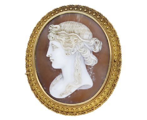 A mid 19th century shell cameo brooch, the shell cameo carved to depict a classical female profile, the bloomed gold mount wi