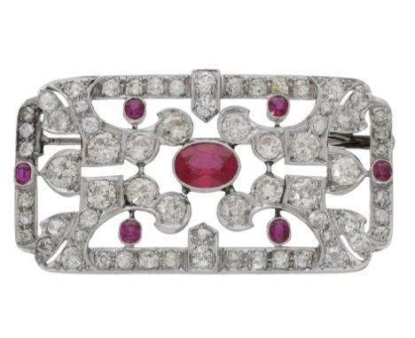 An Art Deco brooch, circa 1930, set centrally with an oval-cut synthetic ruby, the pierced plaque surround set throughout wit