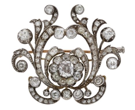 A late 19th century diamond brooch, the openwork cartouche with scroll and flowerhead detailing, set throughout with cushion-