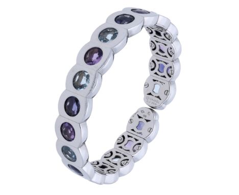 A gem-set ‘Coco’ bangle by Chanel, the sprung cuff formed of barrel-shaped panels set with circular-shaped iolites, amethysts
