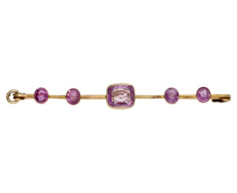 An early 20th century pink sapphire five stone bar brooch, collet-set throughout with vari-cut pink sapphires, mounted in gol