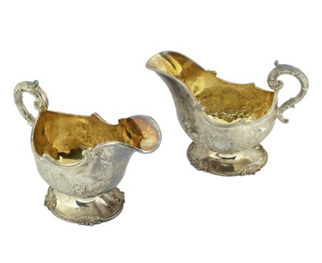 A pair of Victoria silver sauceboats, the bodies repoussé decorated with C-scrolls and foliage, with moulded, leaf cast scrol