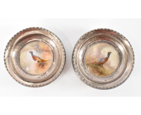 A pair of early 20th Century James Stinton for Royal Worcester ceramic plaques being set within hallmarked silver trinket dis