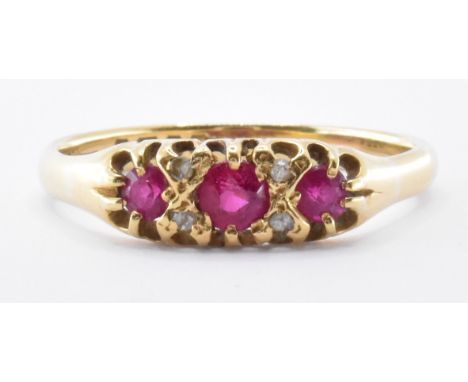 A hallmarked 18ct gold 1920's Art Deco era ring being set with three round cut rubies with four diamond accent stones. Hallma