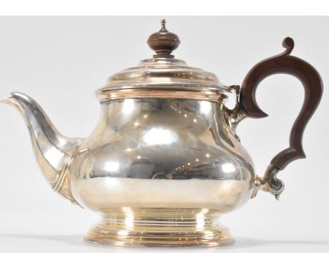 A hallmarked silver Adie Brothers George V 1920s teapot. The teapot having a carved wood knop with silver finial atop on a hi