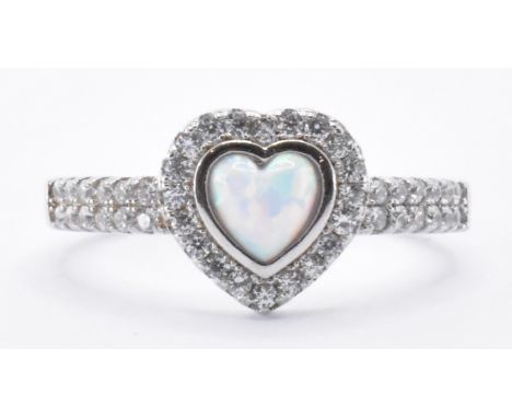 A silver and opal ring being set with a central heart shaped opal with CZ accent stones set to the head and shoulders. Marked