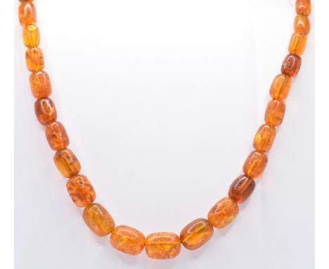 A vintage amber beaded necklace being strung with thirty five graduating cylindrical shaped beads with a screw clasp. Measure