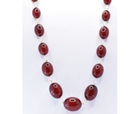 A vintage cherry bakelite beaded necklace having oval beads with alternate clear faceted beads. Measures 67cm. Weight 70.9g.&