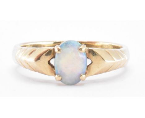 A 9ct gold and opal ring. The ring being set with an oval opal cabochon with incised details to the shoulders. Marked 9k, tes